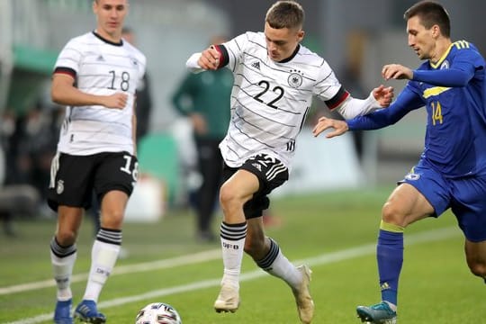 Florian Wirtz (M) kämpft mit Mateo Maric (r) aus Bosnien-Herzegowina um den Ball.
