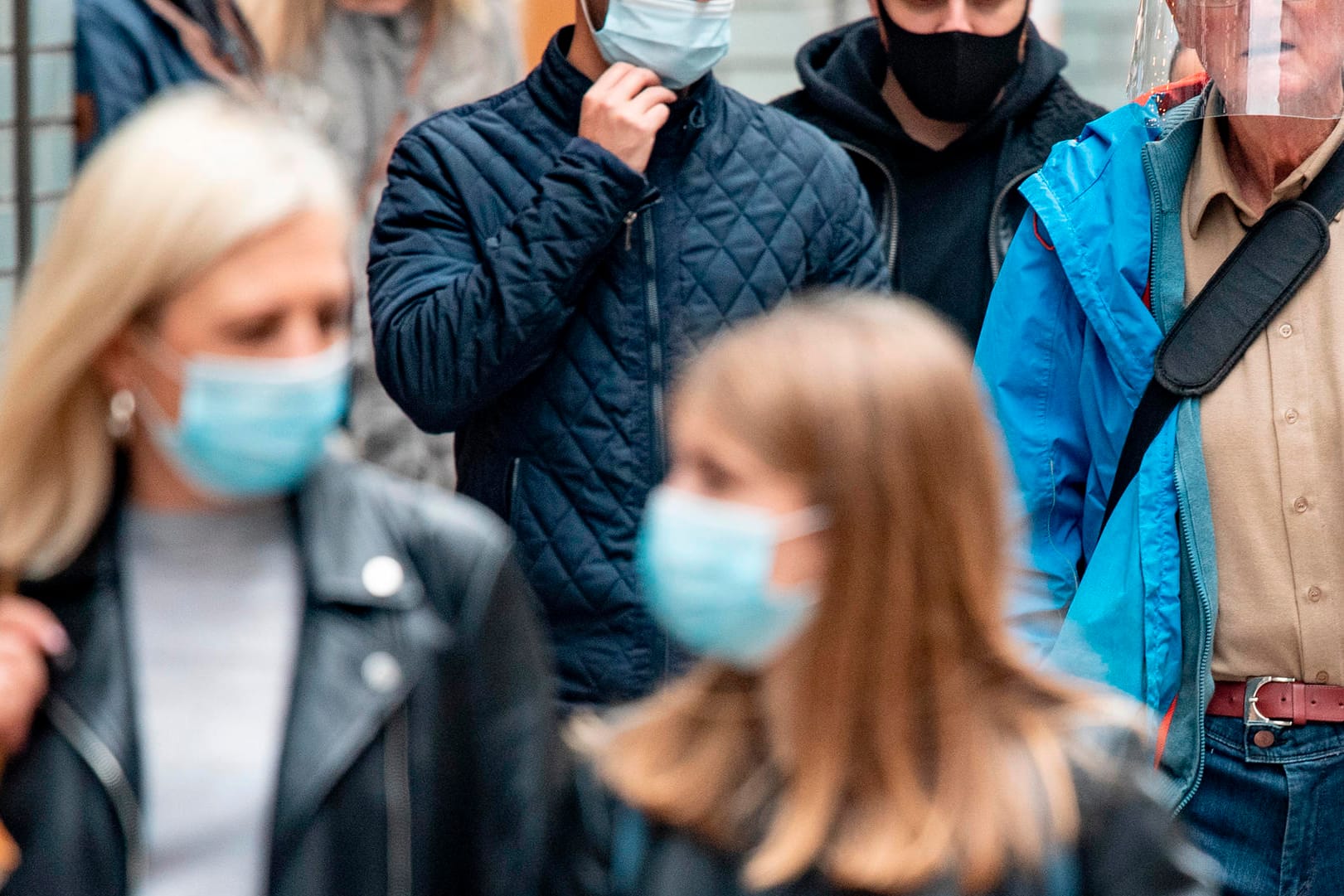 Passanten mit Mund-Nase-Schutz laufen durch eine Fußgängerzone (Symbolbild): In Essen können Corona-Verstöße per Online-Formular gemeldet werden.