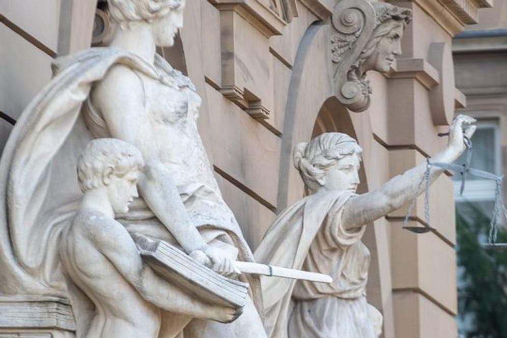 Vor einem Gerichtsgebäude steht u.a. eine Statue der Justitia