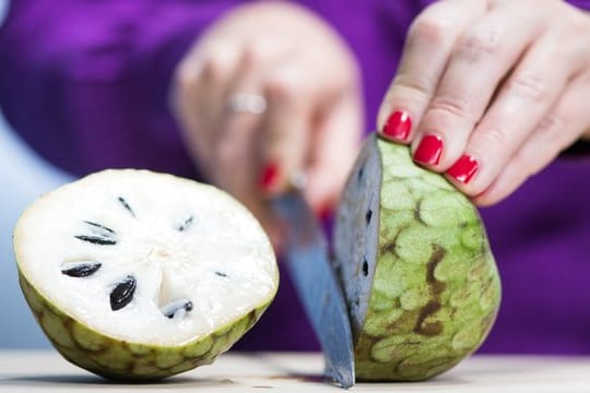 Die Cherimoya kann nach dem Halbieren wie eine Kiwi ausgelöffelt werden - aber ohne die Kerne, denn die sind nicht essbar.