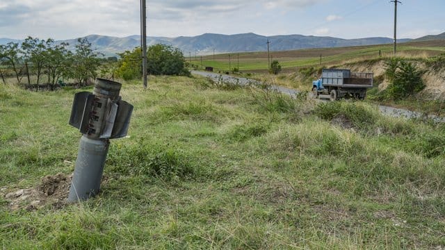Ein Blindgänger steckt auf einer Wiese im Boden fest, nachdem das Dorf Martuni seitens der aserbaidschanischen Armee beschossen wurde. Ein Blindgänger steckt auf einer Wiese im Boden fest, nachdem das Dorf Martuni seitens der aserbaidschanischen Armee beschossen wurde.