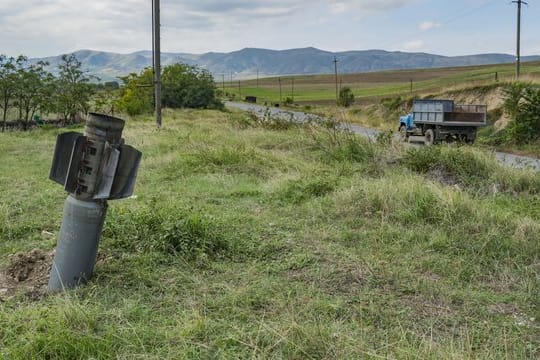 Ein Blindgänger steckt auf einer Wiese im Boden fest, nachdem das Dorf Martuni seitens der aserbaidschanischen Armee beschossen wurde.