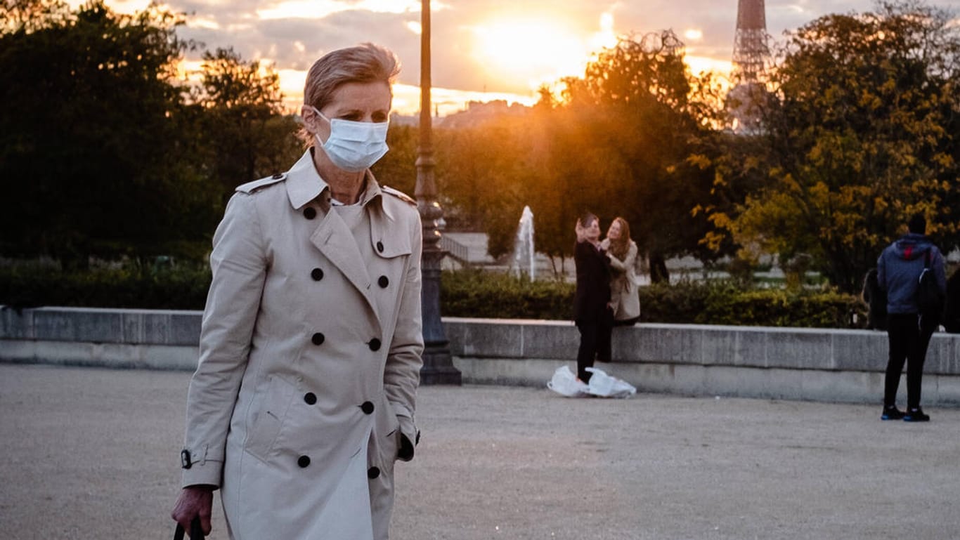 Passantin mit Maske in Paris: Die Zahlen der Neuinfektionen mit dem Coronavirus steigen an vielen Orten Frankreichs stark an.