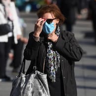 Fußgänger mit Mund-Nasen-Schutz: An dieses Stadtbild werden sich die Menschen wohl langfristig gewöhnen müssen.