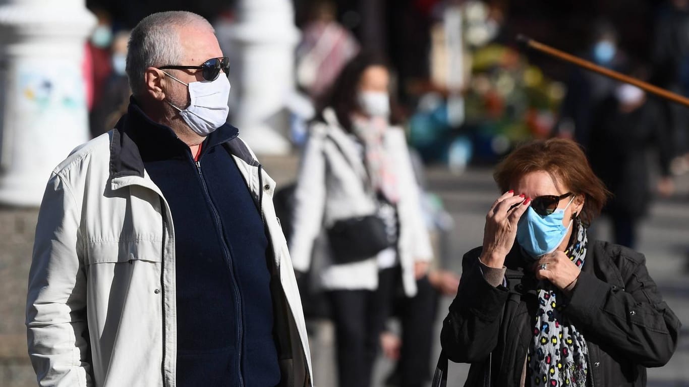 Fußgänger mit Mund-Nasen-Schutz: An dieses Stadtbild werden sich die Menschen wohl langfristig gewöhnen müssen.