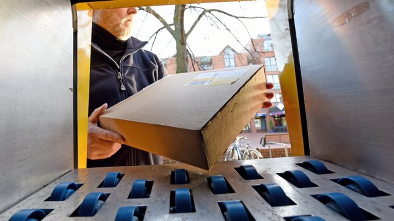 Ein Mann holt ein Paket (Symbolbild): Wer die automatische Umleitung aktiviert, erhält seine Pakete an die voreingestellte Packstation oder Postfiliale.