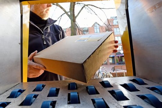 Ein Mann holt ein Paket (Symbolbild): Wer die automatische Umleitung aktiviert, erhält seine Pakete an die voreingestellte Packstation oder Postfiliale.