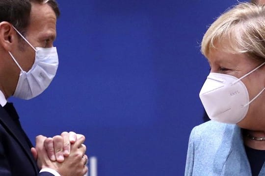 Emmanuel Macron (l), Präsident von Frankreich, und Bundeskanzlerin Merkel sprechen während einer Diskussion am runden Tisch im Rahmen des EU-Gipfels.