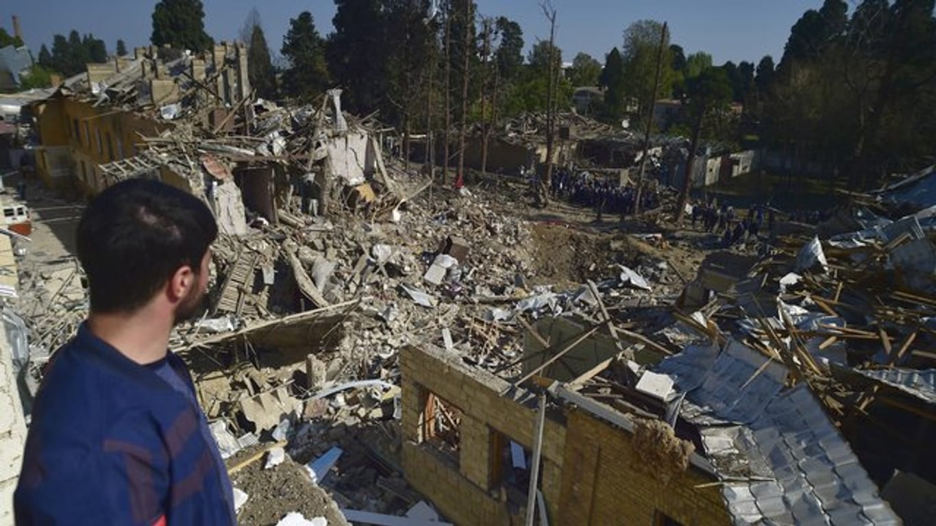 Ein Mann betrachtet die Überreste von Häusern, die durch armenischen Artilleriebeschuss zerstört wurden.