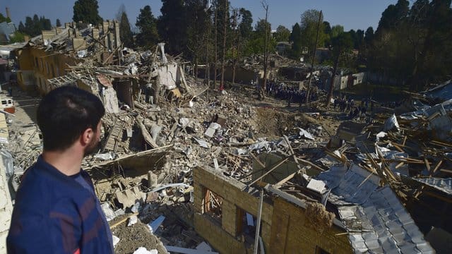Ein Mann betrachtet die Überreste von Häusern, die durch armenischen Artilleriebeschuss zerstört wurden. Ein Mann betrachtet die Überreste von Häusern, die durch armenischen Artilleriebeschuss zerstört wurden.