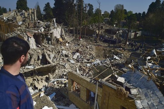 Ein Mann betrachtet die Überreste von Häusern, die durch armenischen Artilleriebeschuss zerstört wurden.
