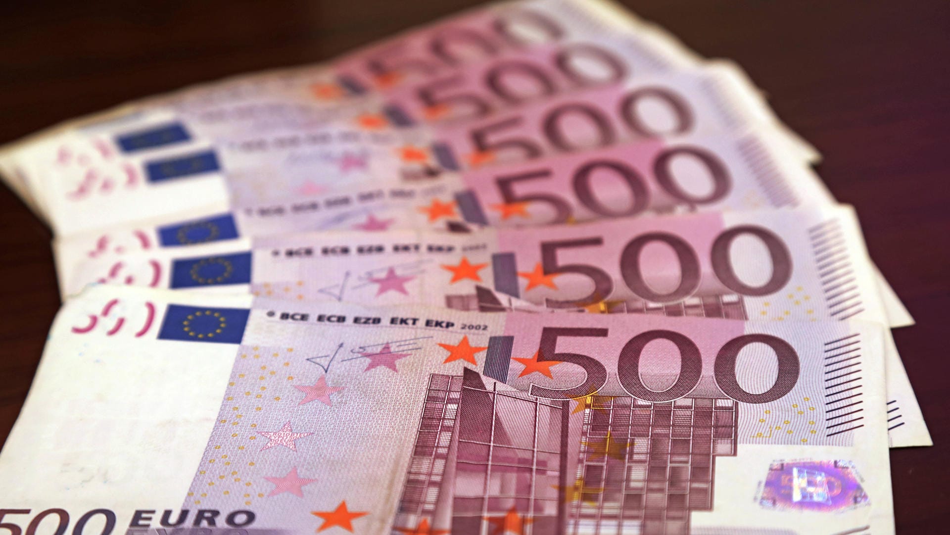 500-Euro-Scheine liegen aufgereiht auf einem Tisch (Symbolbild): Ein Mann in Wuppertal hatte gefälschte Varianten davon im Gepäck.