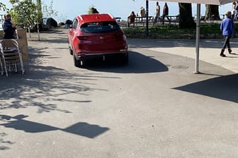 Ein rotes Auto an einem Ufer: Ein Mann hat mir einer Fotoidee für einen Unfall gesorgt.