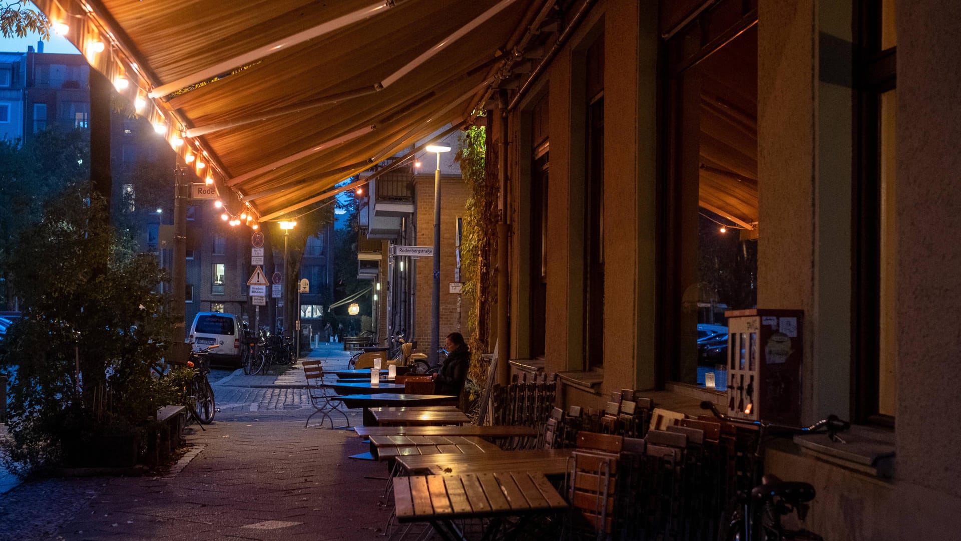 Nur ein Gast sitzt an den Tischen vor einem Restaurant in Berlin-Prenzlauer Berg: Das Berliner Verwaltungsgericht hat die Sperrstunde in der Hauptstadt gekippt.