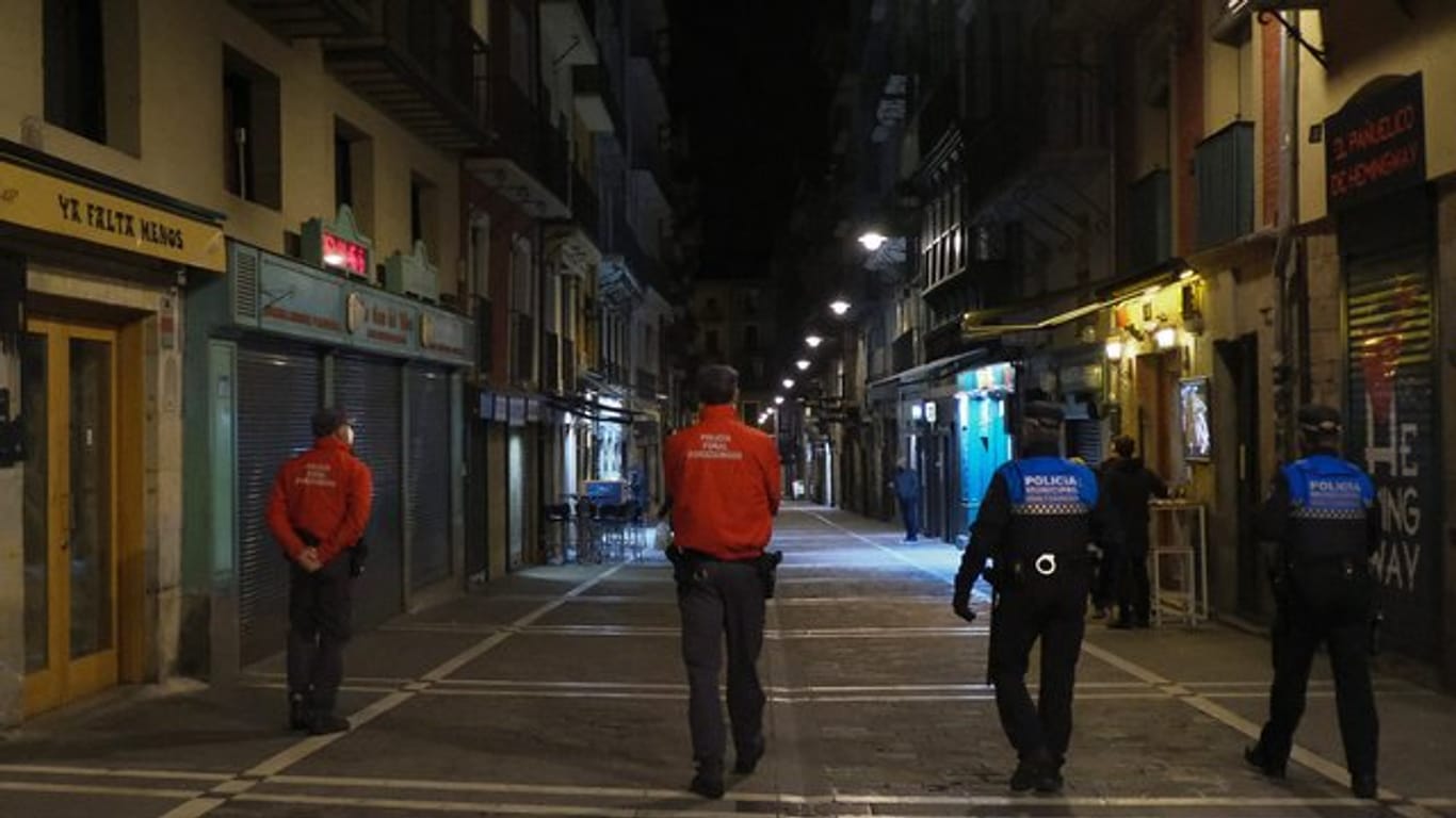 Polizisten patrouillieren auf einer Straße in Pamplona, bevor alle Bars und Restaurants um 22 Uhr geschlossen werden.
