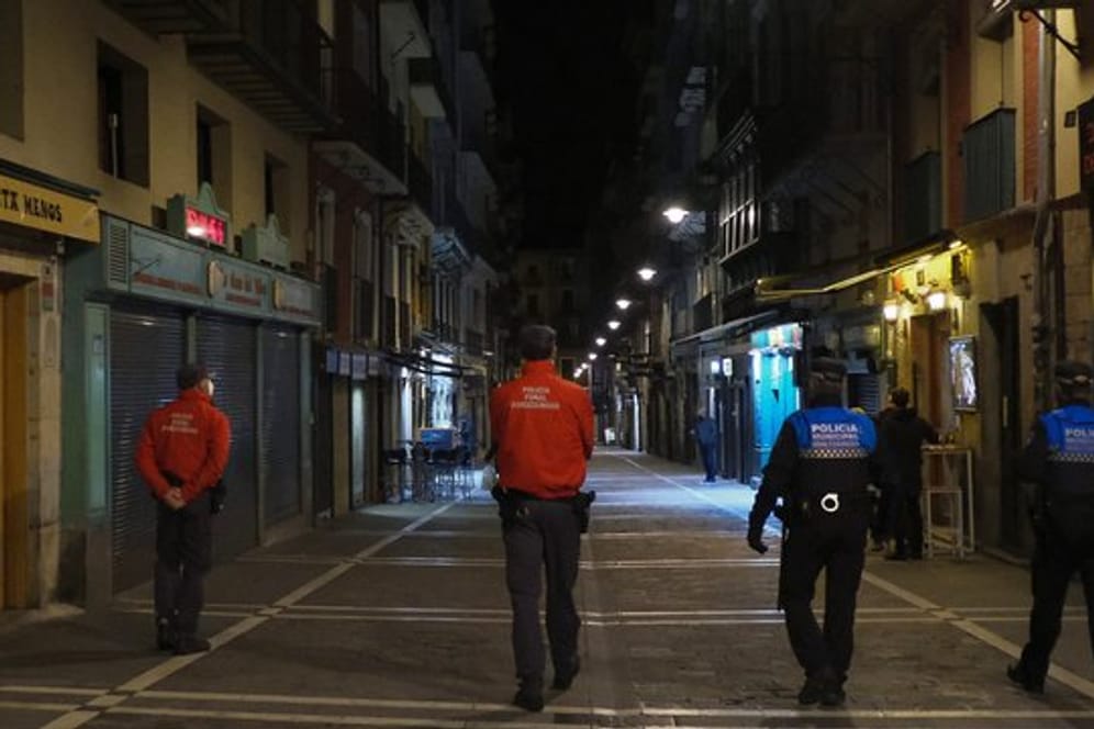 Polizisten patrouillieren auf einer Straße in Pamplona, bevor alle Bars und Restaurants um 22 Uhr geschlossen werden.