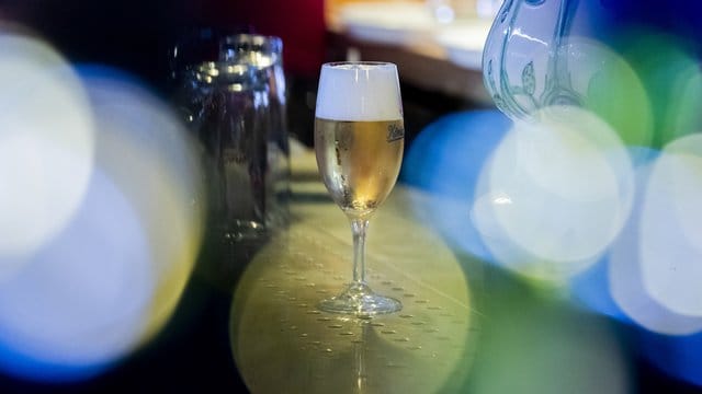 Ein Glas Bier steht in einer Kneipe auf der Theke