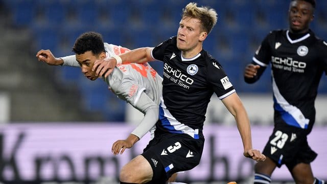 Jamal Musiala (l) von Bayern in Aktion gegen Brian Behrendt (M) von Bielefeld. Jamal Musiala (l) von Bayern in Aktion gegen Brian Behrendt (M) von Bielefeld.