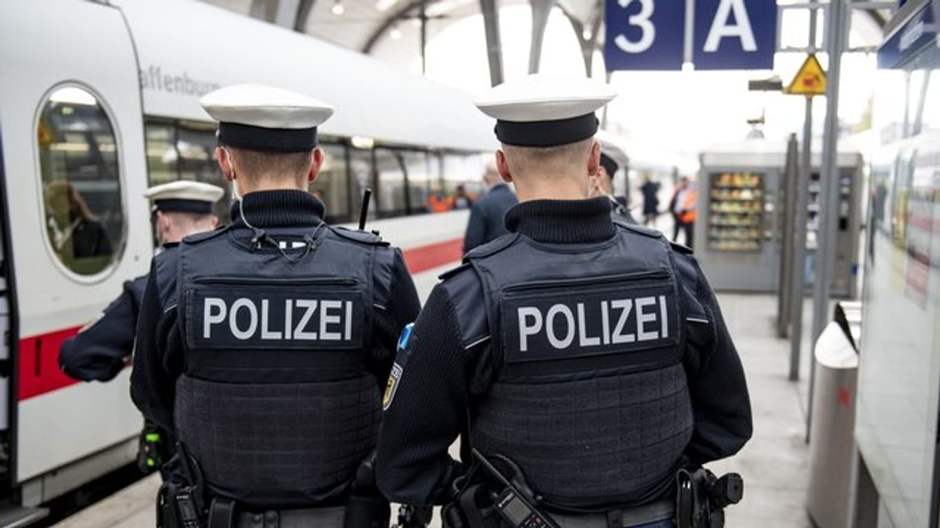 Bundespolizisten stehen vor der Abfahrt eines ICE an einem Gleis im Kieler Hauptbahnhof.