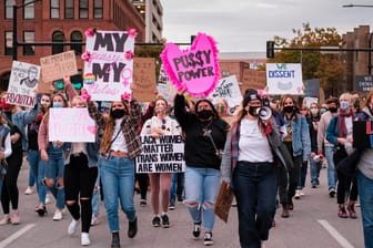 Frauen mit Mund-Nasen-Schutz halten Protestschilder in die Höhe: Frauen von New York bis San Francisco waren zu einer Demonstration aufgerufen, um Widerstand gegen US-Präsident Trump und seine Politik zu signalisieren.