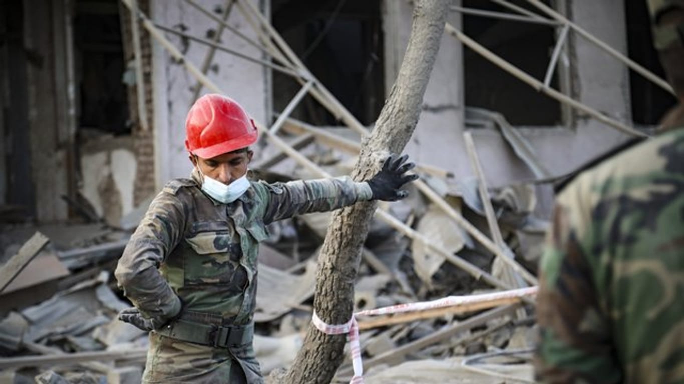 Ein aserbaidschanischer Soldat steht in der Nähe eines zerstörten Hauses in einem Wohngebiet, das von armenischen Streitkräften durch Raketenbeschuss getroffen wurde.