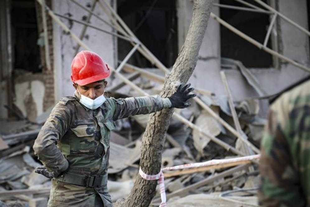 Ein aserbaidschanischer Soldat steht in der Nähe eines zerstörten Hauses in einem Wohngebiet, das von armenischen Streitkräften durch Raketenbeschuss getroffen wurde.