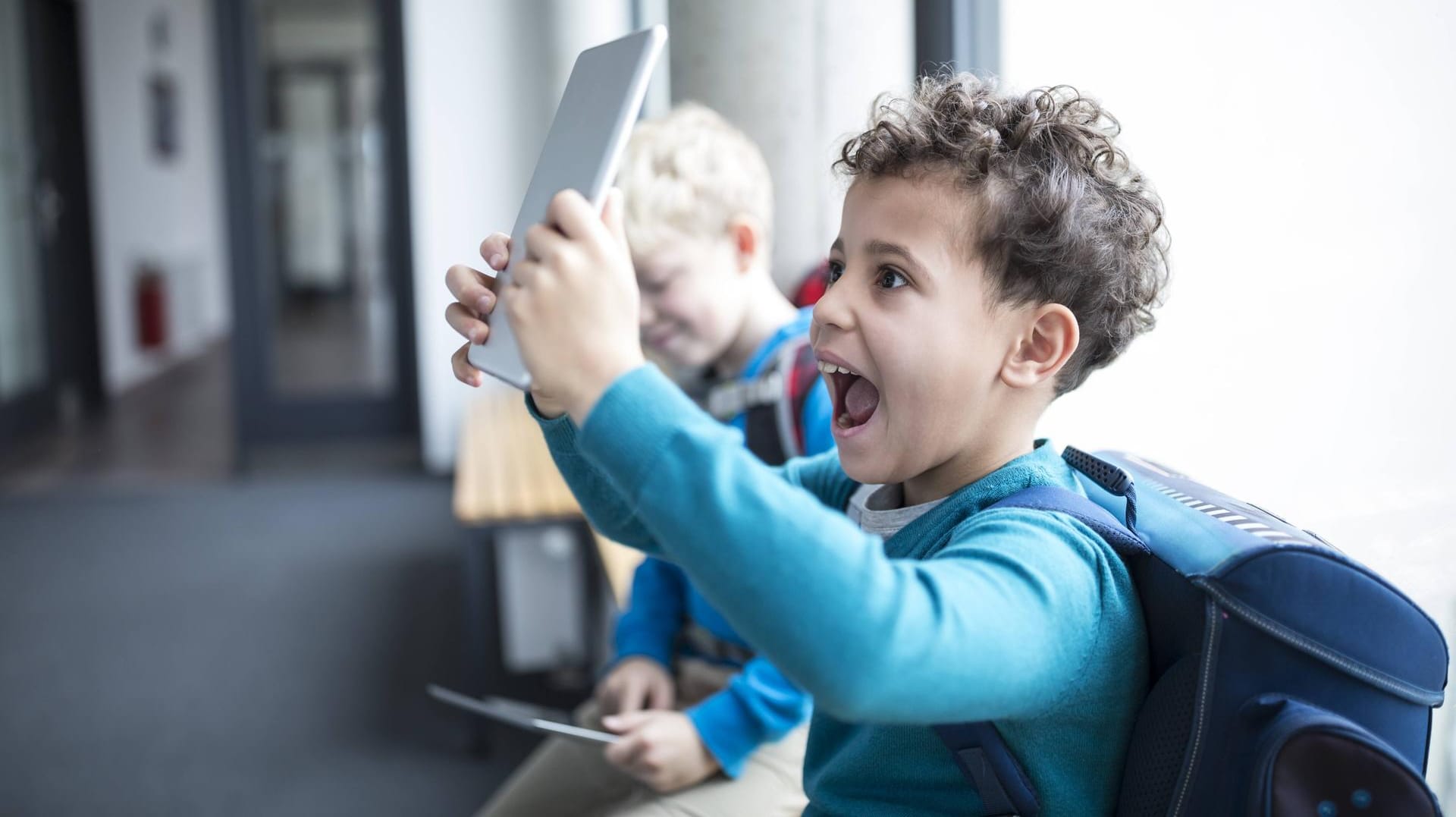 Endlich da: Ein Schüler ist glücklich über ein neues Tablet.