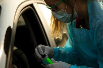 Eine Helferin in den USA nimmt einen Coronavirus-Test an einem Autofenster: Seit Frühjahr kämpften Staaten auf der ganzen Welt gegen die Ausbreitung der Pandemie. (Archivbild)