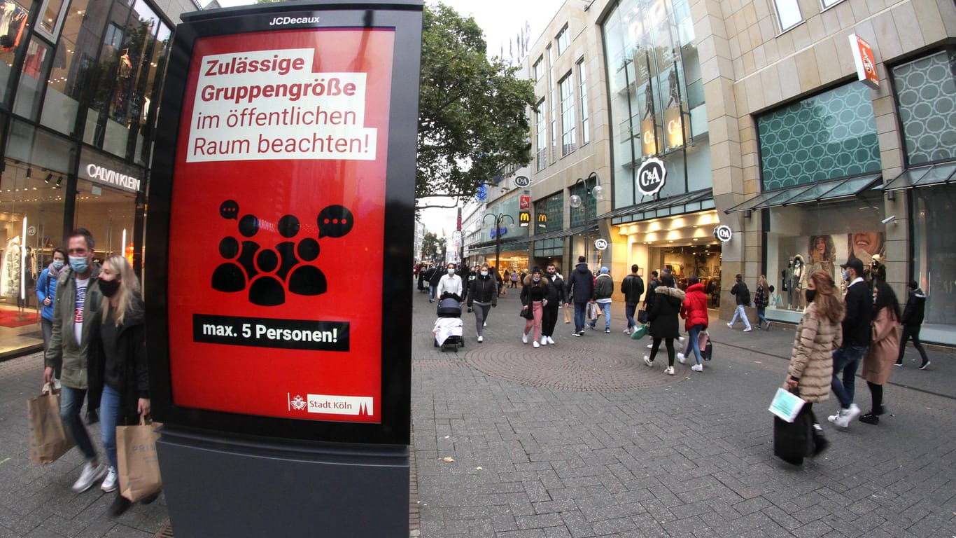 Eine Werbetafel erinnert Kölner an die zulässige Gruppengröße im öffentlichen Raum: Nun sind neue Beschränkungen für Feiern in Kraft getreten.