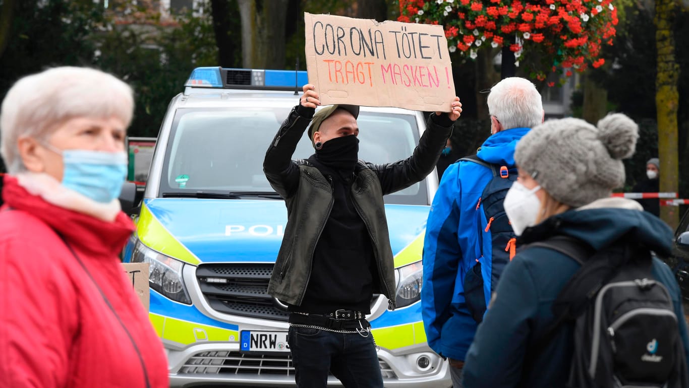 Dortmund: Ein Demonstrant wirbt mit einem Schild für das Tragen eines Mundschutzes.