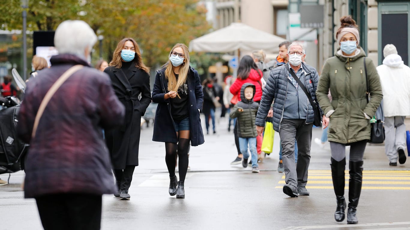 Zürich: Passanten mit Schutzmasken unterwegs an der Bahnhofstrasse. Die Schweiz hat nach einem heftigen Anstieg der Infektionszahlen strengere Regeln erlassen.