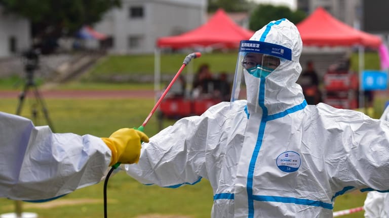 Medizinisches Personal in Schutzanzügen wird im Süden Chinas desinfiziert: China hat nach offiziellen Angaben das Coronavirus im Griff.