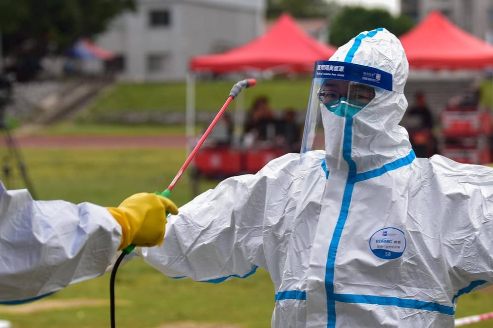 Medizinisches Personal in Schutzanzügen wird im Süden Chinas desinfiziert: China hat nach offiziellen Angaben das Coronavirus im Griff.