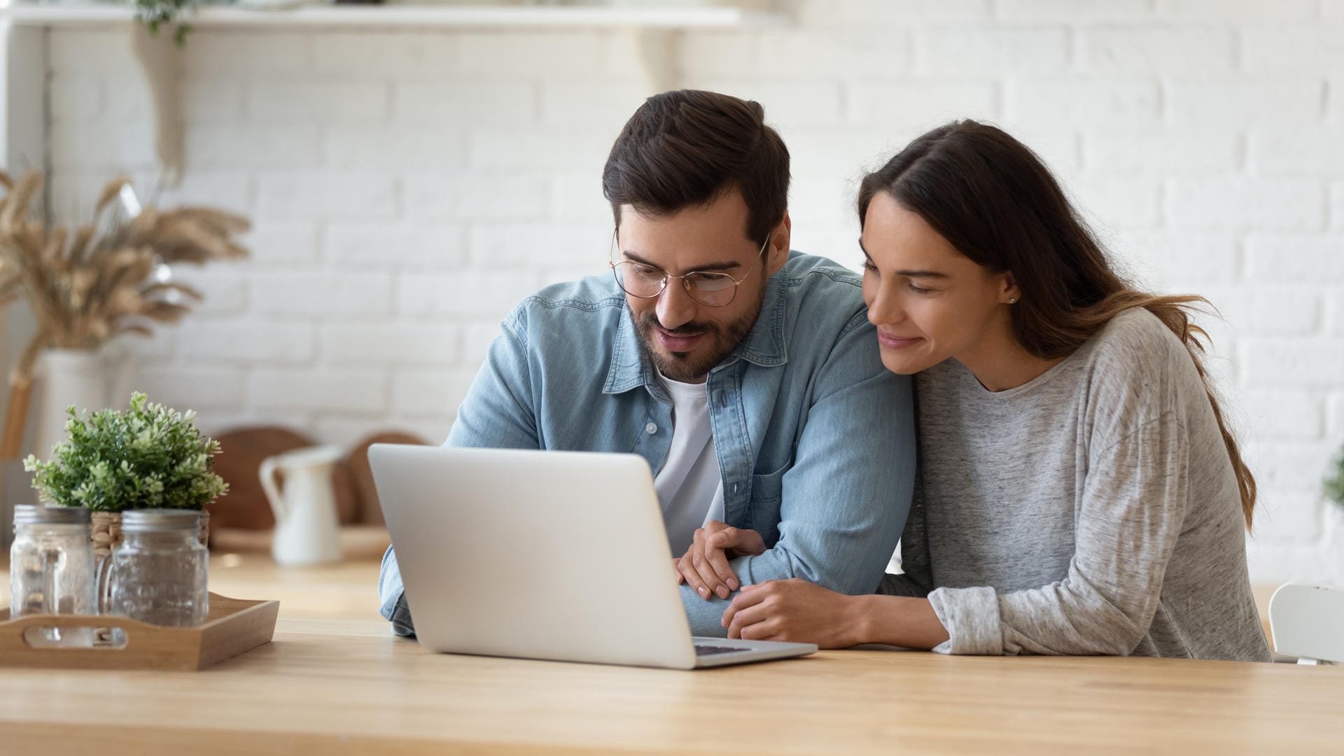 Ein Pärchen lehnt sich über einen Laptop: Google zeigt personalisierte Werbung.