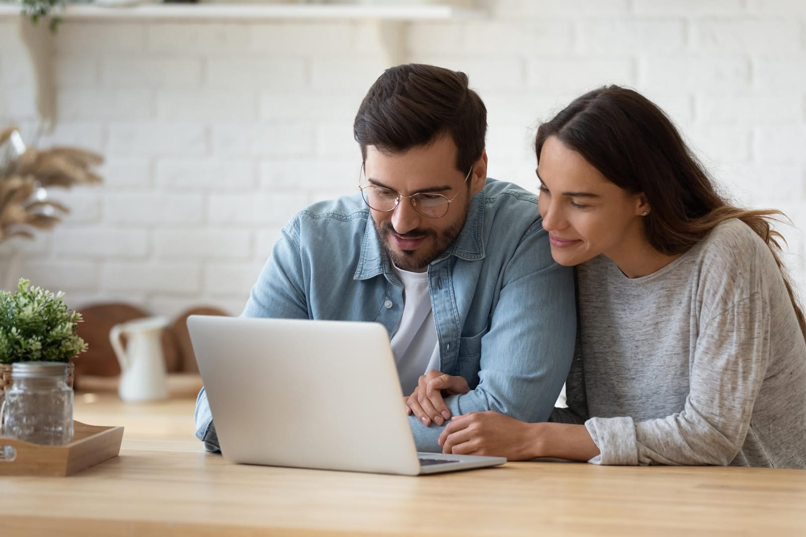 Ein Pärchen lehnt sich über einen Laptop: Google zeigt personalisierte Werbung.