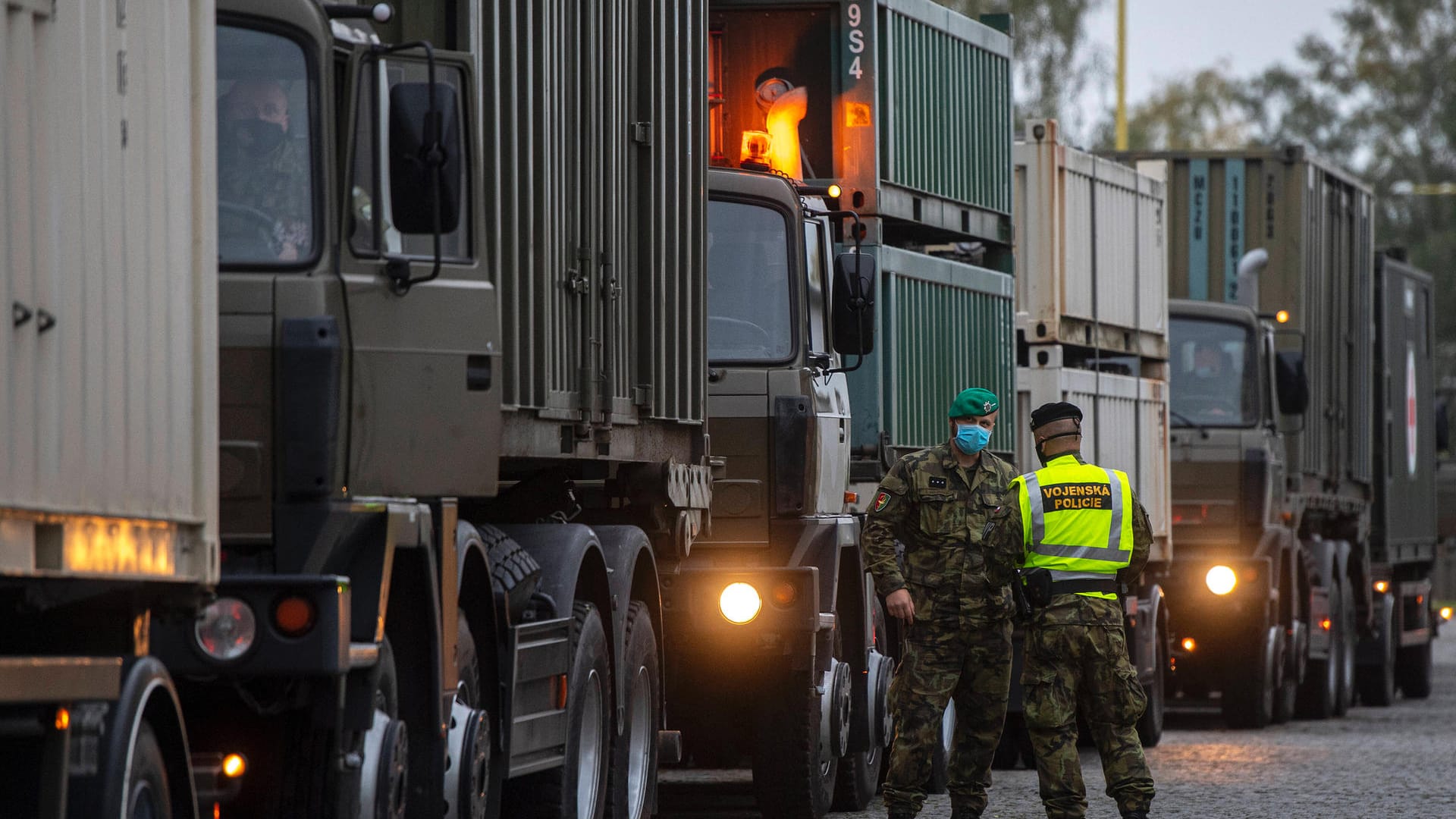 Soldaten stehen vor Lastwagen: Der Konvoi transportiert ein Feldkrankenhaus nach Prag. Soldaten stehen vor Lastwagen: Der Konvoi transportiert ein Feldkrankenhaus nach Prag.