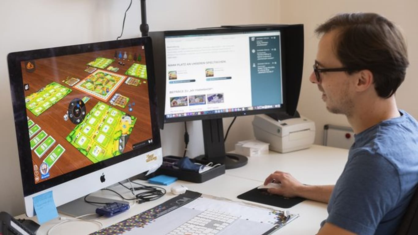 Maximilian Metzler, Mitarbeiter des Spiele Verlages Merz, spielt am Computer das Spiel "My Farm Shop".