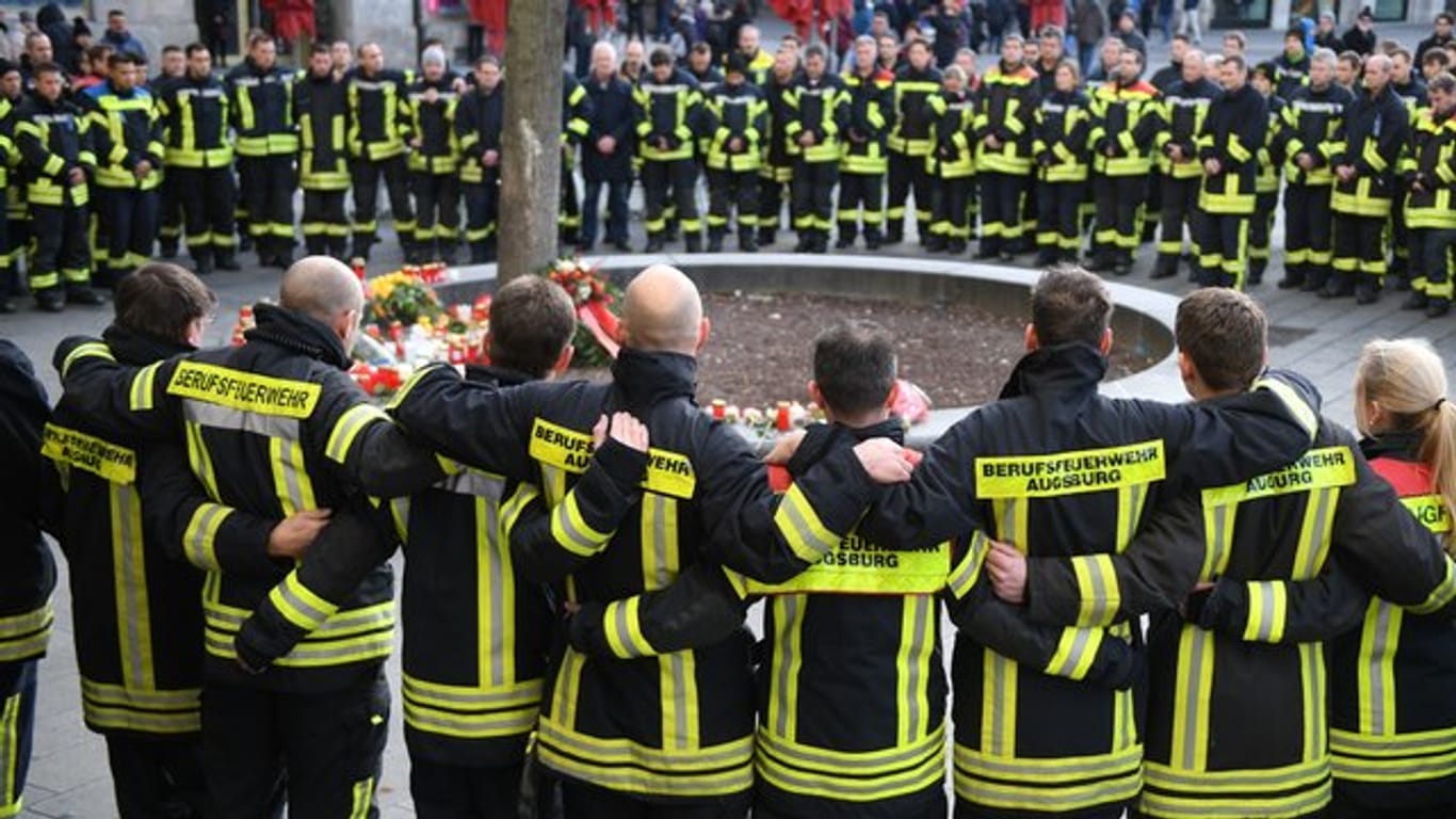 Trauernde Feuerwehrmänner im Dezember 20109 am Königsplatz in Augsburg.