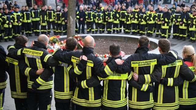 Trauernde Feuerwehrmänner im Dezember 20109 am Königsplatz in Augsburg. Trauernde Feuerwehrmänner im Dezember 20109 am Königsplatz in Augsburg.
