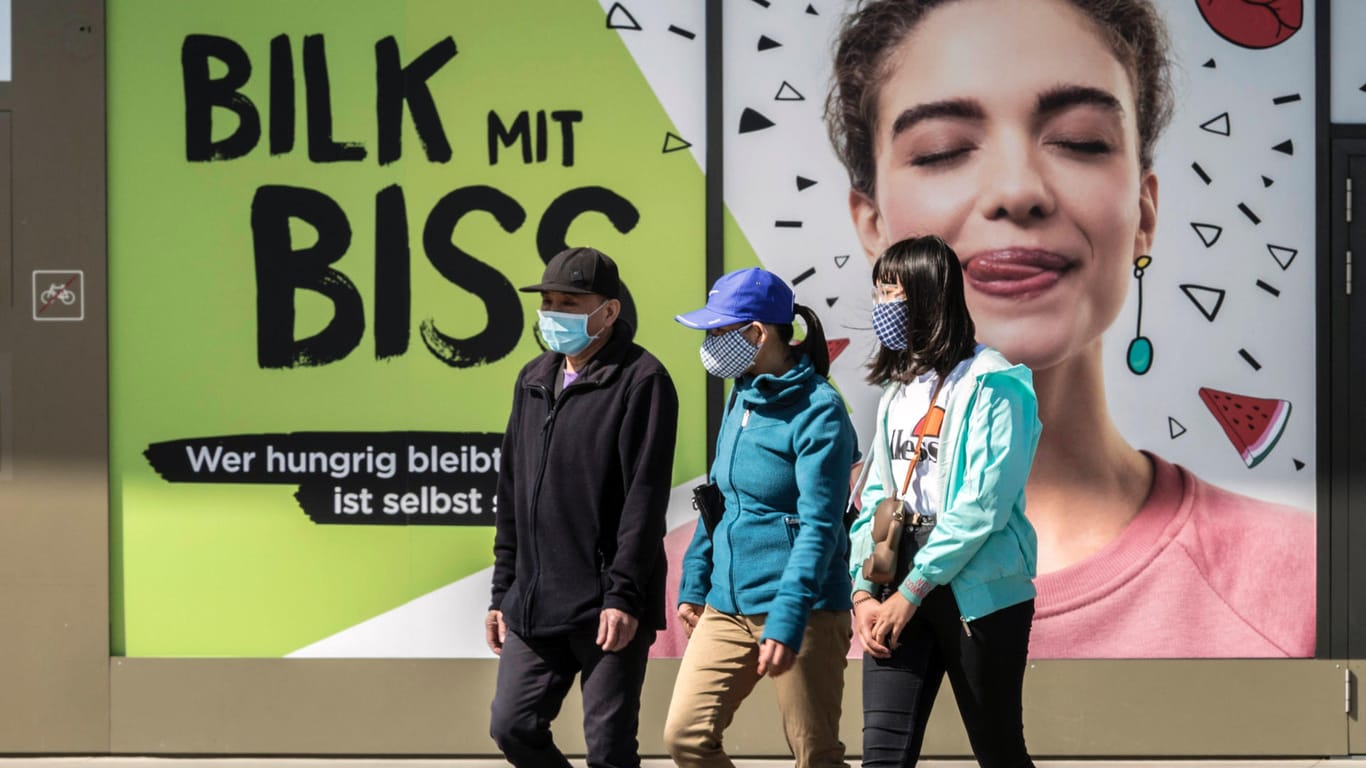 Passanten laufen mit Mund-Nasen-Schutz durch Düsseldorf: Seit Dienstag gilt unter anderem in der Altstadt eine Maskenpflicht.