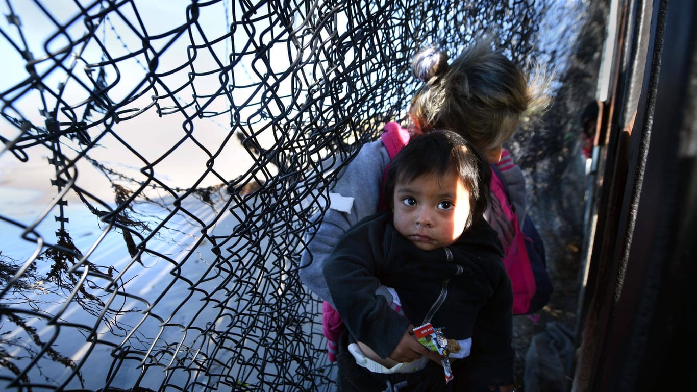 Migranten überwinden den US-Grenzzaun bei Tijuana im Dezember 2018: Damals strömten vermehrt Einwanderer an die Grenze. Die US-Regierung griff hart durch und trennte Eltern von ihren Kindern.