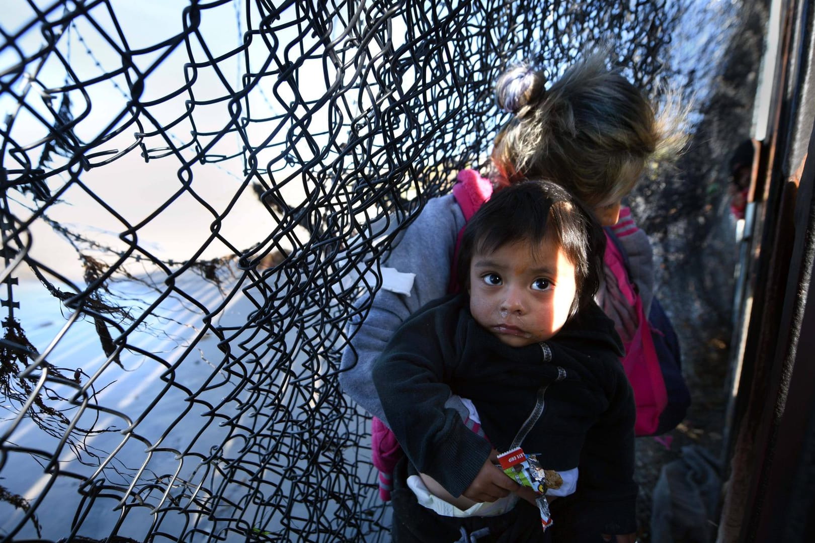 Migranten überwinden den US-Grenzzaun bei Tijuana im Dezember 2018: Damals strömten vermehrt Einwanderer an die Grenze. Die US-Regierung griff hart durch und trennte Eltern von ihren Kindern.