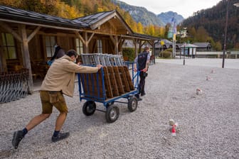 Zwei Mitarbeiter räumen am Königssee einen Biergarten leer: Im Landkreis Berchtesgadener Land gelten strenge Corona-Auflagen.