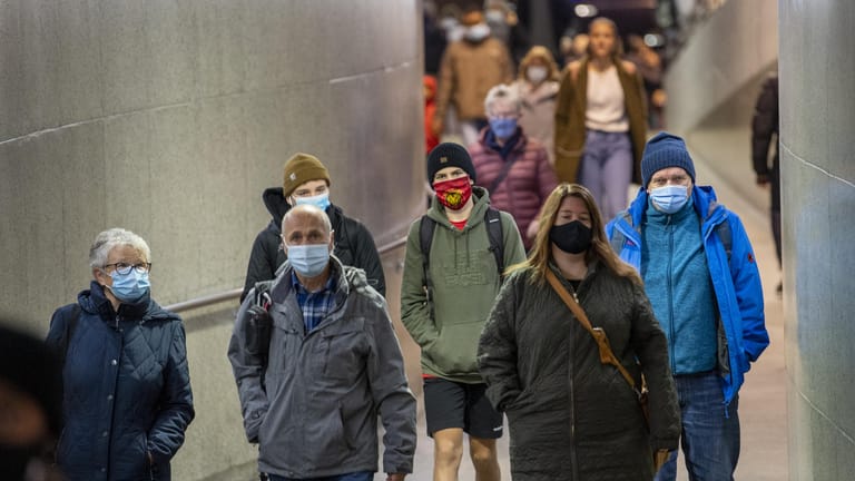 Schweiz, Bern: Zugreisende tragen Mund-Nasen-Schutz im Bahnhof Bern. Deutschland hat für das Land nun eine Reisewarnung erlassen.