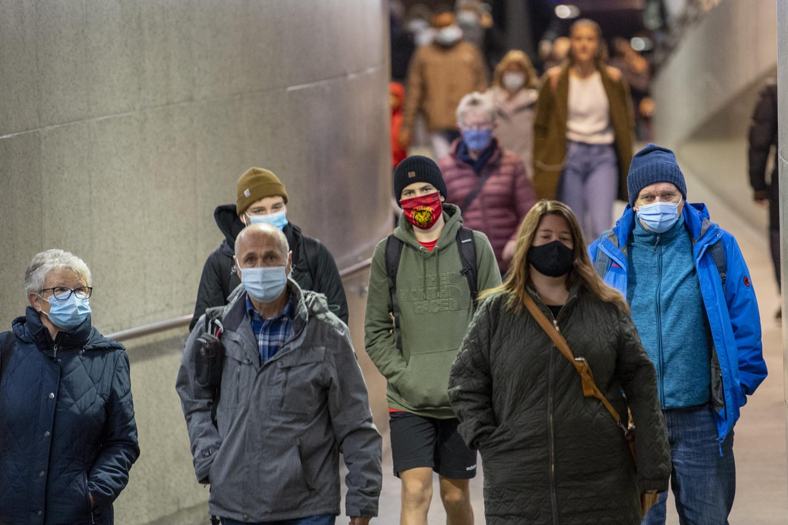 Schweiz, Bern: Zugreisende tragen Mund-Nasen-Schutz im Bahnhof Bern. Deutschland hat für das Land nun eine Reisewarnung erlassen.
