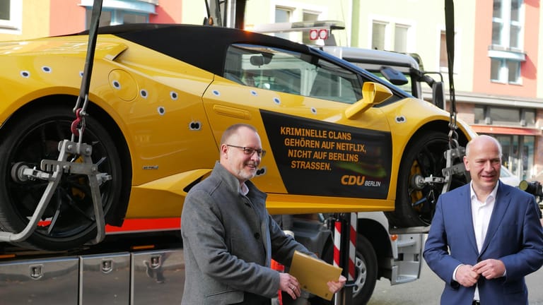 CDU-Landeschef Kai Wegner, CDU-Landeschef und Neuköllns Gesundheitsstadtrat Falko Liecke (CDU) stehen vor einem gemieteten Lamborghini mit aufgeklebten Einschusslöchern: Mit der Aktion sollte auf Clankriminalität aufmerksam gemacht werden.