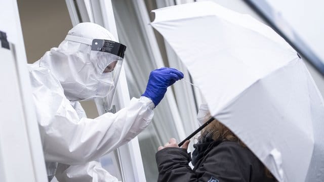 Eine Frau bekommt an der Corona-Teststation am Hauptbahnhof von Köln einen Rachenabstrich.