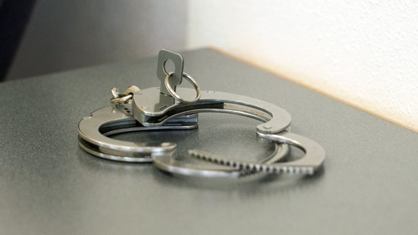 Handschellen liegen auf einem Tisch (Symbolbild): Ein zu lebenslanger Haft verurteilter Mörder muss noch länger hinter Gitter.