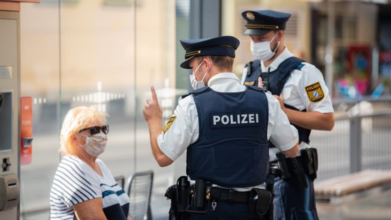 Zwei Polizisten kontrollieren an einer Haltestelle in Halle (Saale) die Maskenpflicht: Der Tramfahrer musste nach dem Angriff ärztlich versorgt werden. (Symbolfoto)