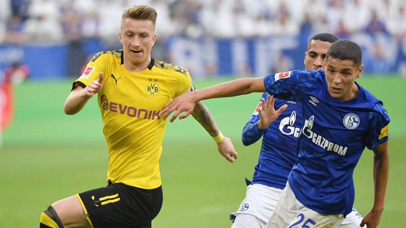 Marco Reus (l.) im Zweikampf mit den Schalkern Mascarell (m.) und Harit: Das Revierderby steht dieses Jahr unter besonderen Vorzeichen.